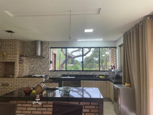 a kitchen with a large window and a counter top at Chácara Recanto Monjolinho in Planaltina