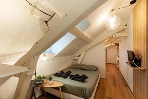 - une petite chambre mansardée avec un lit et une table dans l'établissement Le Loft - studio en Hypercentre - Cathédrale, à Amiens