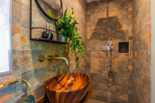 a bathroom with a wooden tub and a shower at Self-contained cosy one bedroom holiday barn in Cowbridge