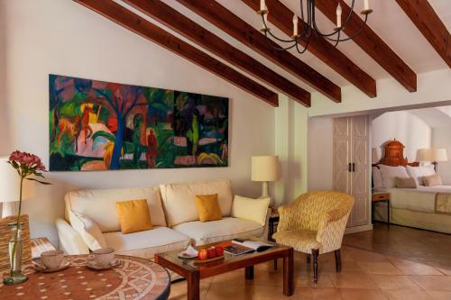 a living room with a white couch and a painting at La Residencia, A Belmond Hotel, Mallorca in Deia