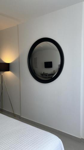 リオデジャネイロにあるLuxuoso Studio em Copacabanaの白い壁に鏡が付いたベッドルーム