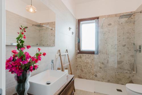 a bathroom with a sink and a vase of flowers at Villa Chiara in Triscina