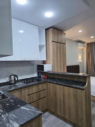 a kitchen with white cabinets and black counter tops at Next 1411 in Kakhaberi