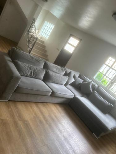 - un grand canapé blanc dans le salon avec fenêtres dans l'établissement Le Aulnay, à Aulnay-sous-Bois