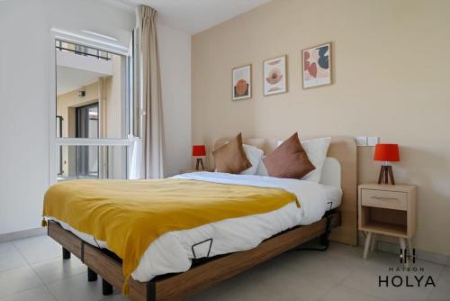une chambre avec un grand lit avec une couverture jaune dans l'établissement Le Solstice - À Avignon - 374B, à Avignon