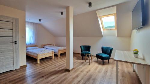 a bedroom with a bed and a table and chairs at Wisienka in Pstrągowa