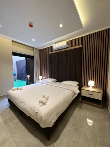 a bedroom with a large bed and a large window at Chic Apartments For Rent ave0-4 in Umm Uthainah