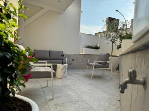 a patio with couches and chairs on a balcony at Domus De Cinti Boutique Rooms in Tivoli