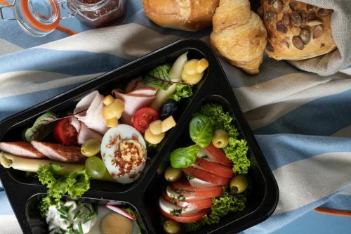 two black containers filled with vegetables and bread at My Tatra Residence in Zakopane