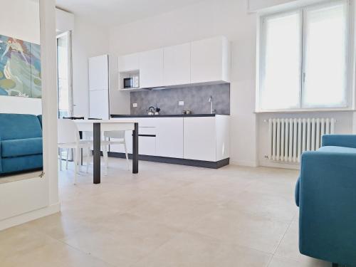 a kitchen with white cabinets and a dining table at Re Lear Expo in Verona