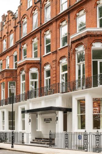 a large red brick building with a black sign on it at Ellen Kensington in London
