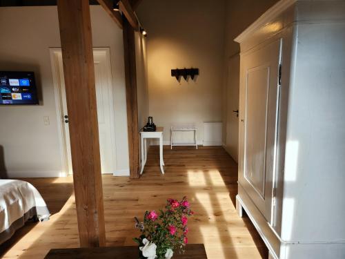 a room with a bed and a table with flowers at Storchenhof Blumenow in Blumenow