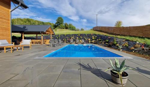 a swimming pool in a yard with a patio at Wisienka in Pstrągowa