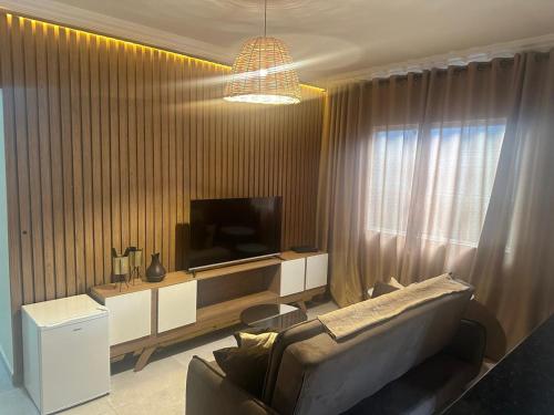 a living room with a couch and a television at CASA DE PRAIA OLONAN BEACH in Itanhaém