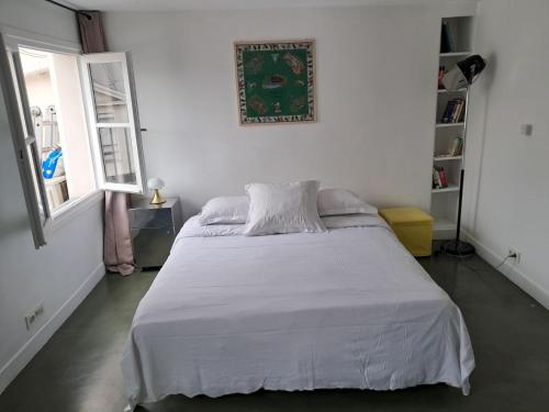 une chambre avec un lit blanc et une fenêtre dans l'établissement Unit 018 Saint Germain des Près - one bedroom apartment 4 pax, à Paris
