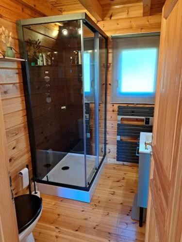La salle de bains en bois est pourvue d'une douche en verre. dans l'établissement chalet - Xonrupt-Longemer, à Xonrupt-Longemer