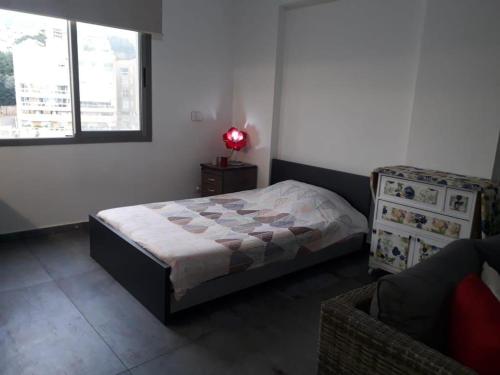 a bedroom with a bed and a chair and a window at Inviting 1-Bed Apartment in Dbayeh in Dbayeh