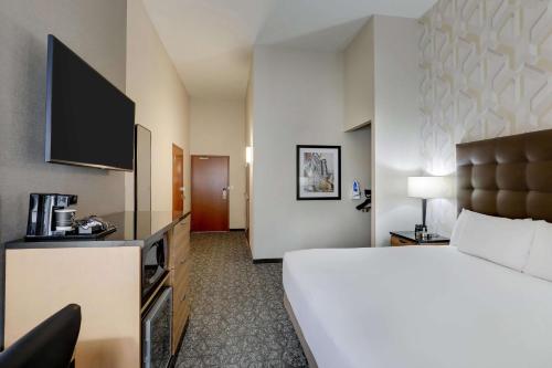 a hotel room with a bed and a television at Drury Inn & Suites Birmingham Lakeshore Drive in Birmingham