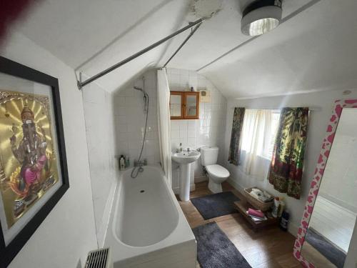 a bathroom with a bath tub and a toilet at Glastonbury 2-Bed House Sleeps 6 & Pet Friendly in Glastonbury