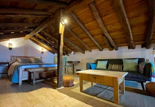 a bedroom with a bed and a couch and a table at La Manzana in Villafruel