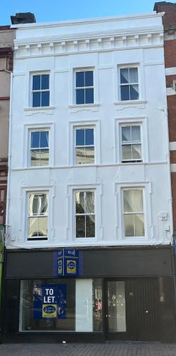 a white building with a clock in front of it at Patrick Street Townhouse in Cork