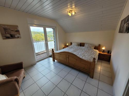 ハイムバッハにあるVakantiewoning - Thuis in Heimbachのベッドと大きな窓のある寝室