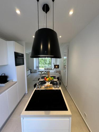 une cuisine avec une lampe noire suspendue au-dessus d'une cuisinière dans l'établissement Apt moderne et luxueux a Cannes Res Miramar, à Cannes