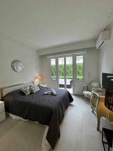 une chambre avec un lit, un bureau et une télévision dans l'établissement Apt moderne et luxueux a Cannes Res Miramar, à Cannes
