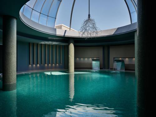 a swimming pool in a building with a glass ceiling at Port Royal Villas and Spa - Adults Only in Kolimbia