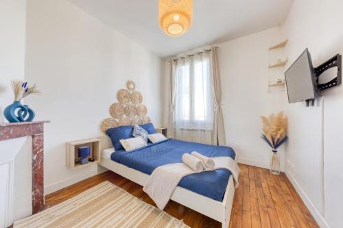 1 dormitorio con cama azul y chimenea en Appartement chic proche gare de Clamart + Netflix, en Malakoff