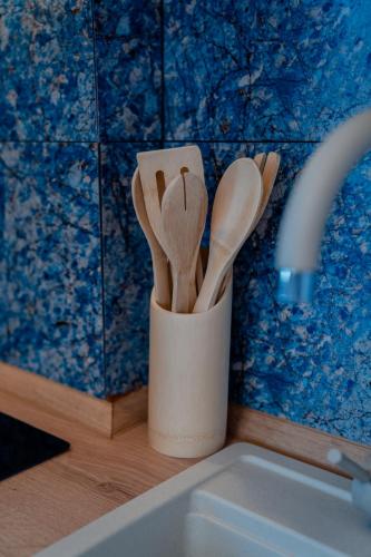 a cup filled with wooden spoons next to a sink at Villa Elena - Dolni Saraj in Ohrid