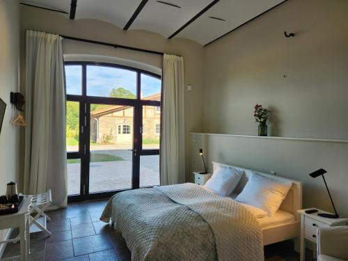 a bedroom with a bed and a large window at Storchenhof Blumenow in Blumenow