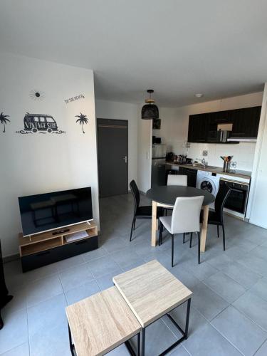 un salon avec une table et une cuisine dans l'établissement La Paillote, à Labenne