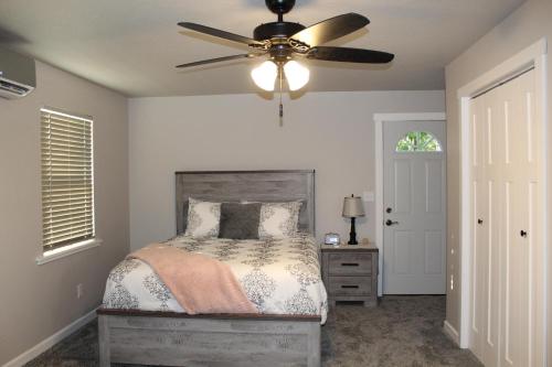 une chambre avec un lit et un ventilateur de plafond dans l'établissement Cozy Corner Cottage, à Wellston