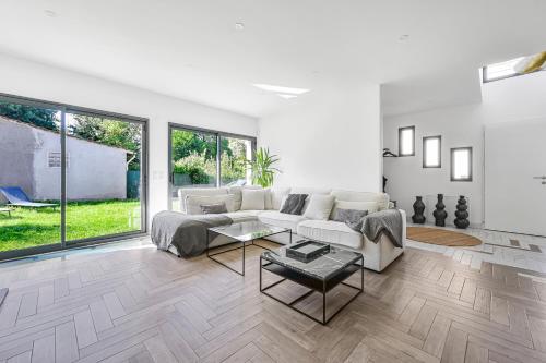 un salon avec un canapé et une table dans l'établissement L'Harmonie - 8P - 4BDR - 3BR - Jardin & Parking, à Cachan