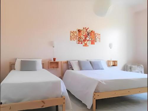アヴォラにあるBORGO MARINARO casa vacanzaの白い壁の部屋にベッドが2つある