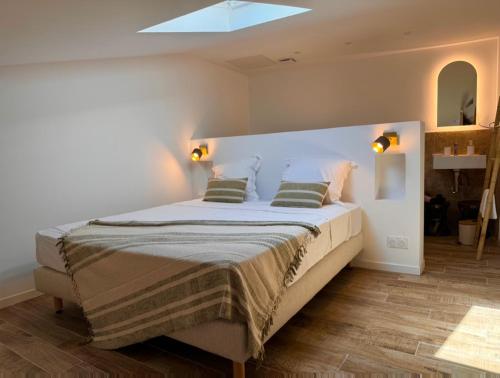 une chambre avec un grand lit avec deux oreillers dans l'établissement Le Buisson Caché, à Buisson