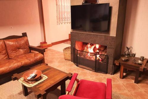 a living room with a fireplace with a television at Cabana - Piscina - Lago - Pet - 50min Curitiba in Tijucas do Sul