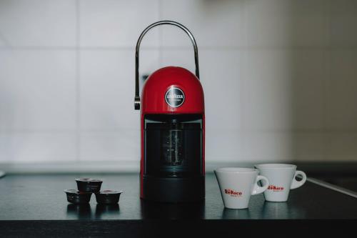 a red blender sitting on a table with two cups at Cavour Luxury Apartments in Verona