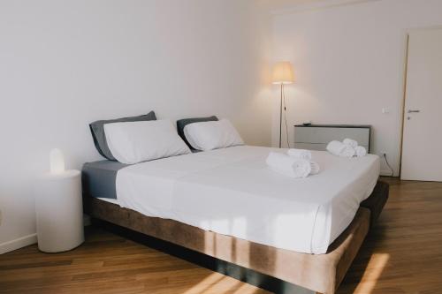 a bedroom with a white bed with towels on it at Cavour Luxury Apartments in Verona