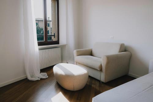 a living room with a chair and a ottoman at Cavour Luxury Apartments in Verona