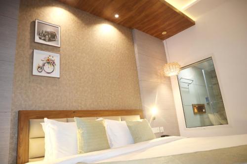 a bedroom with a large bed with white pillows at The TeaTree Munnar in Suryanelli