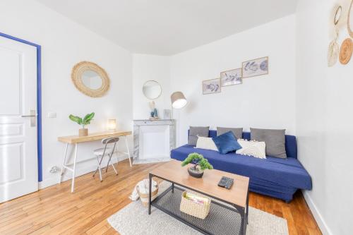 un salon avec un canapé bleu et une table dans l'établissement Appartement chic proche gare de Clamart + Netflix, à Malakoff