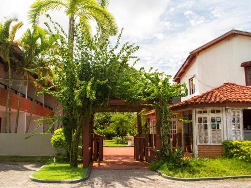 a courtyard of a house with a palm tree at Pousada Larimor in Boicucanga