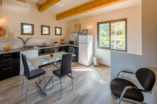 une cuisine avec une table, des chaises et un réfrigérateur dans l'établissement Casa Kallinina, à Esigna