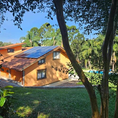 a house with a solar panel on the side of it at Cabana - Piscina - Lago - Pet - 50min Curitiba in Tijucas do Sul