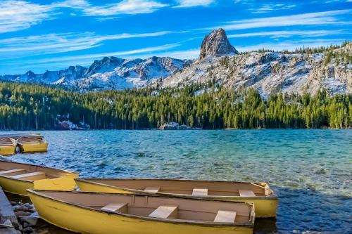 two boats on the shore of a lake with mountains at The Bridges 102 in Mammoth Lakes