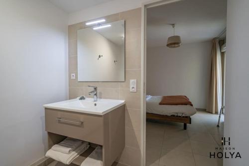 une salle de bain avec un lavabo, un miroir et un lit dans l'établissement Le Soyeux - À Avignon - 375B, à Avignon