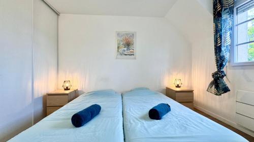 une chambre avec un lit avec des oreillers bleus dessus dans l'établissement Maison 8min de Disney 6 couchages, à Magny-le-Hongre