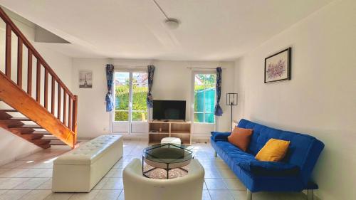un salon avec un canapé bleu et une télévision dans l'établissement Maison 8min de Disney 6 couchages, à Magny-le-Hongre